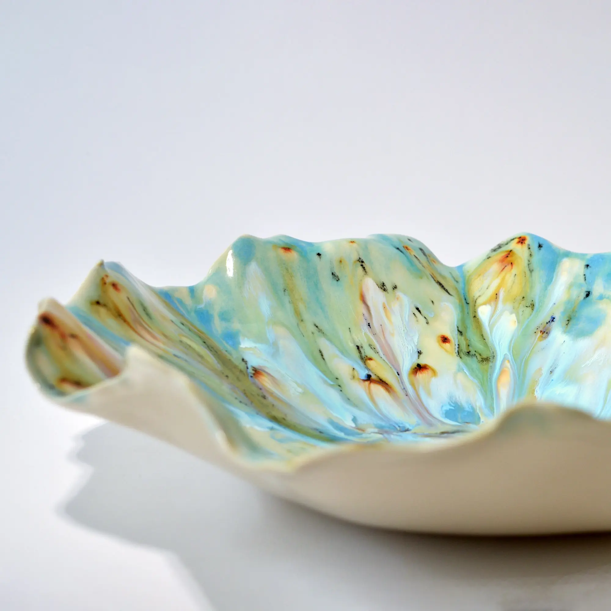 Ruffled porcelain bowl with blue, white, and amber glaze from the Sea Reflections collection.