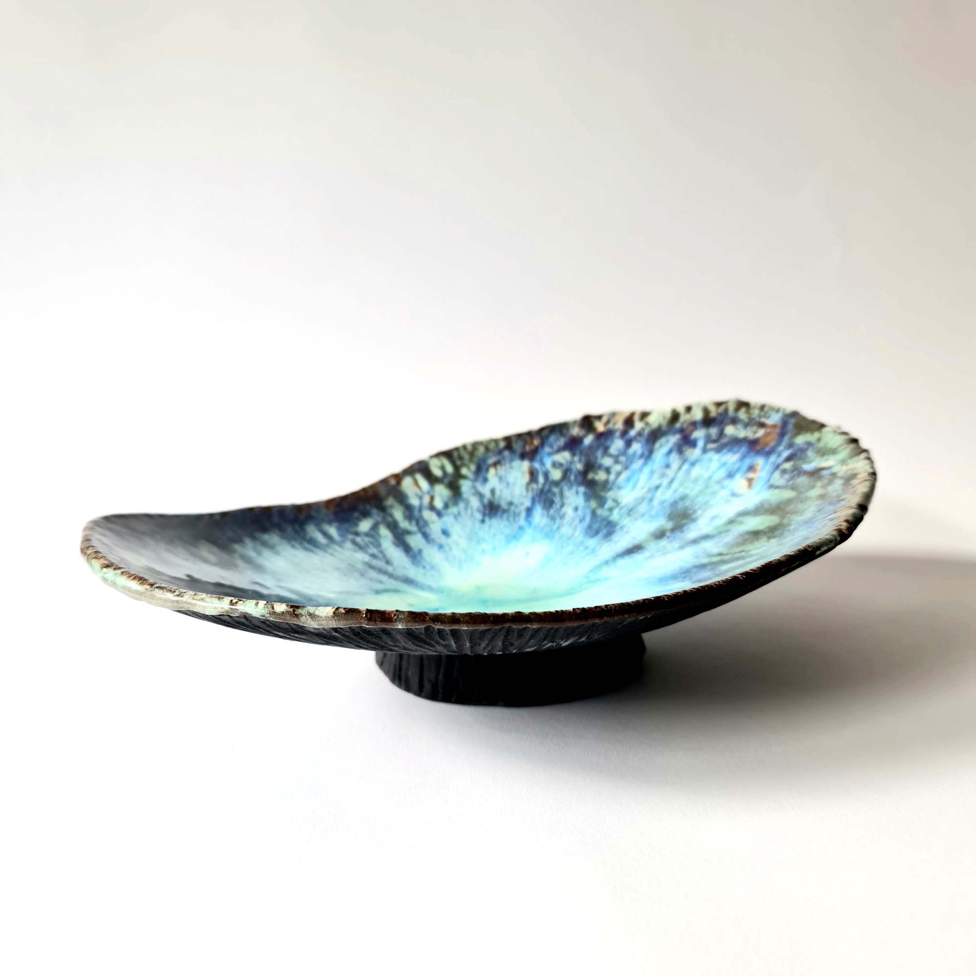 ocean creatures elongated serving bowl (5) Sculptural bowl in black porcelain with layered blue floating glazes and textured exterior